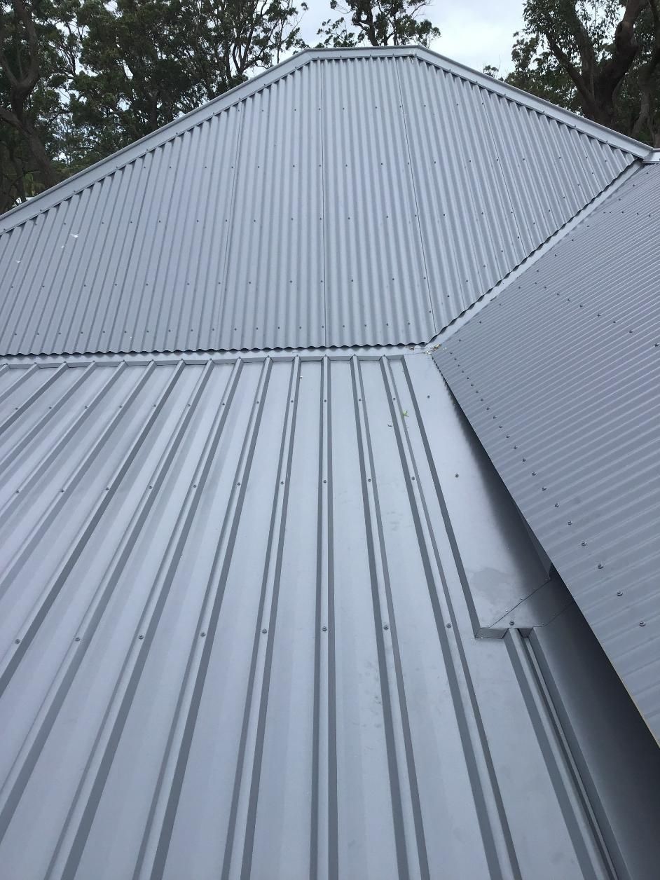 A Close Up Of A Metal Roof With Trees In The Background — Glenroofing Pty Ltd In Taree, NSW