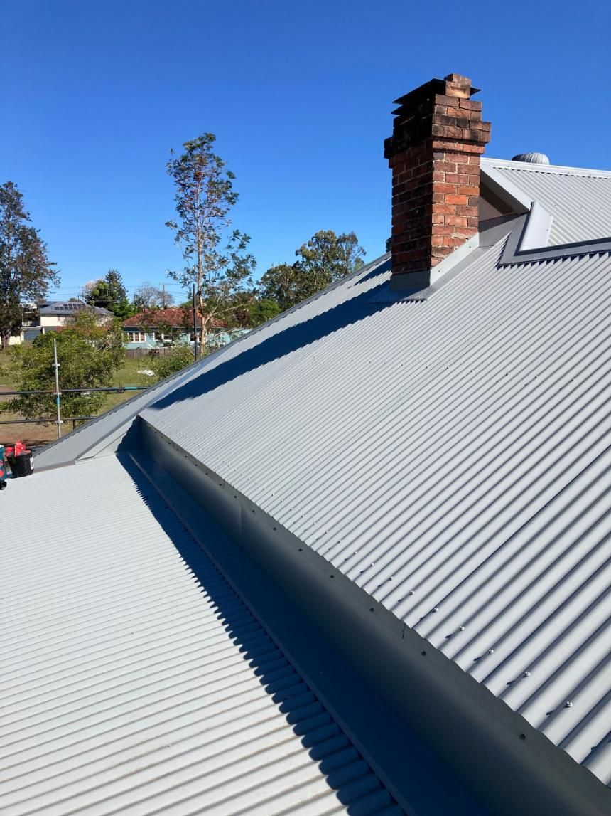 A White Roof With A Chimney On Top Of It — Glenroofing Pty Ltd In Taree, NSW
