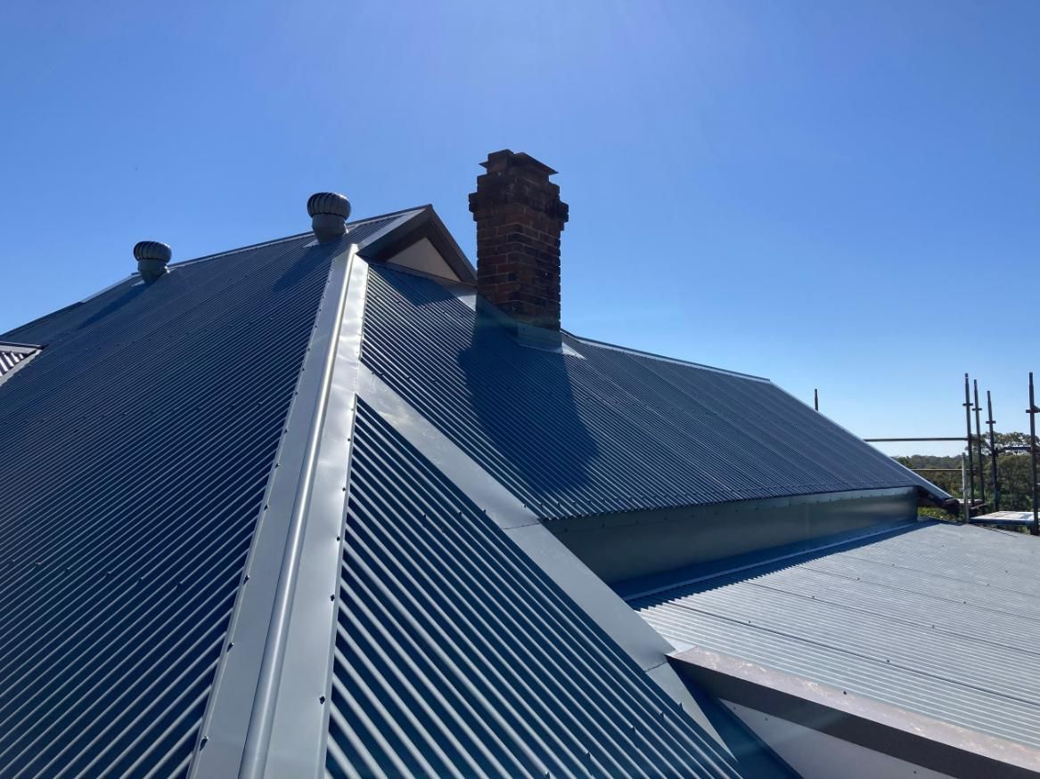 A Blue Roof With A Chimney On Top Of It — Glenroofing Pty Ltd In Taree, NSW