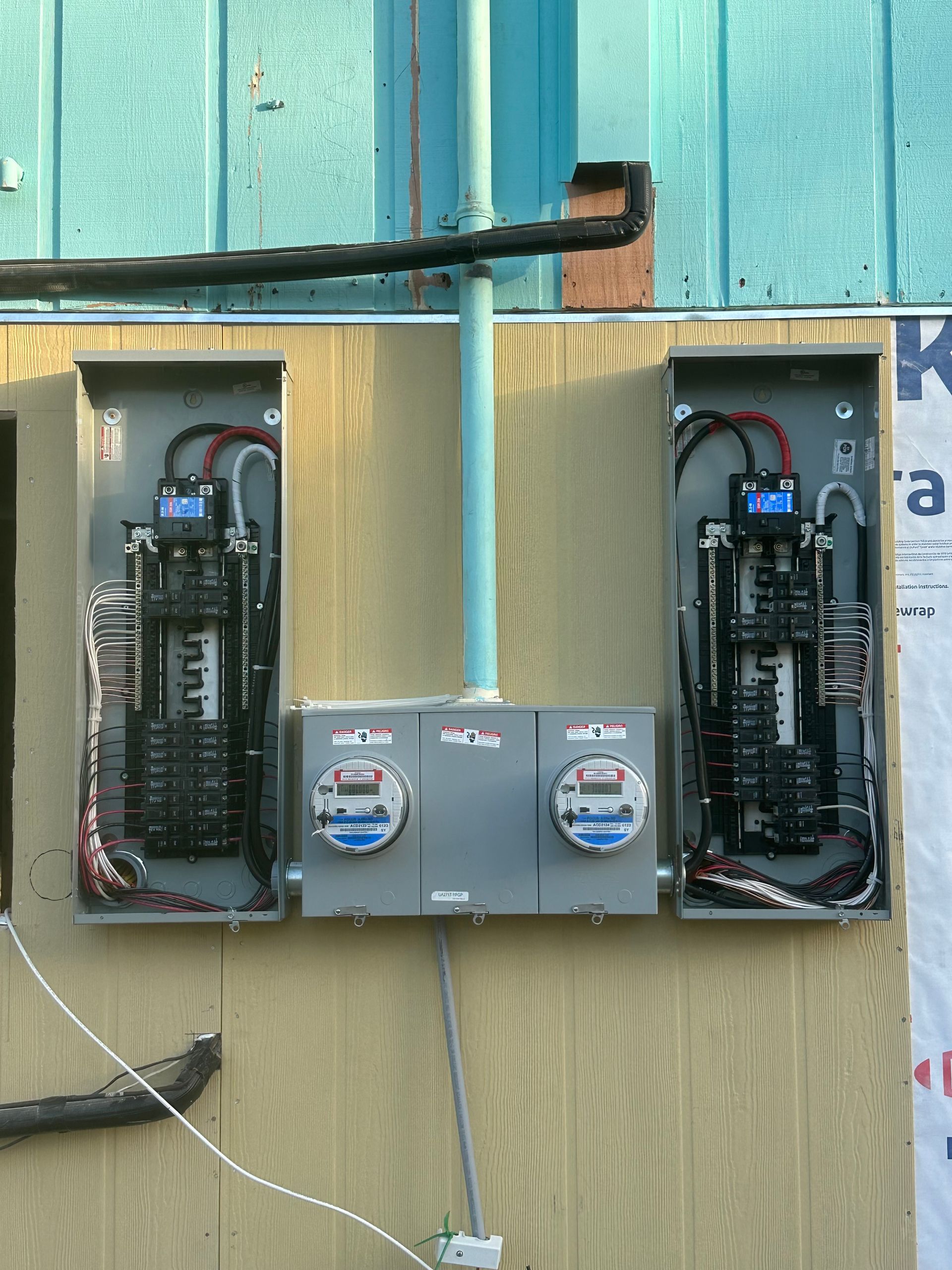 Three electrical panels on the side of a building