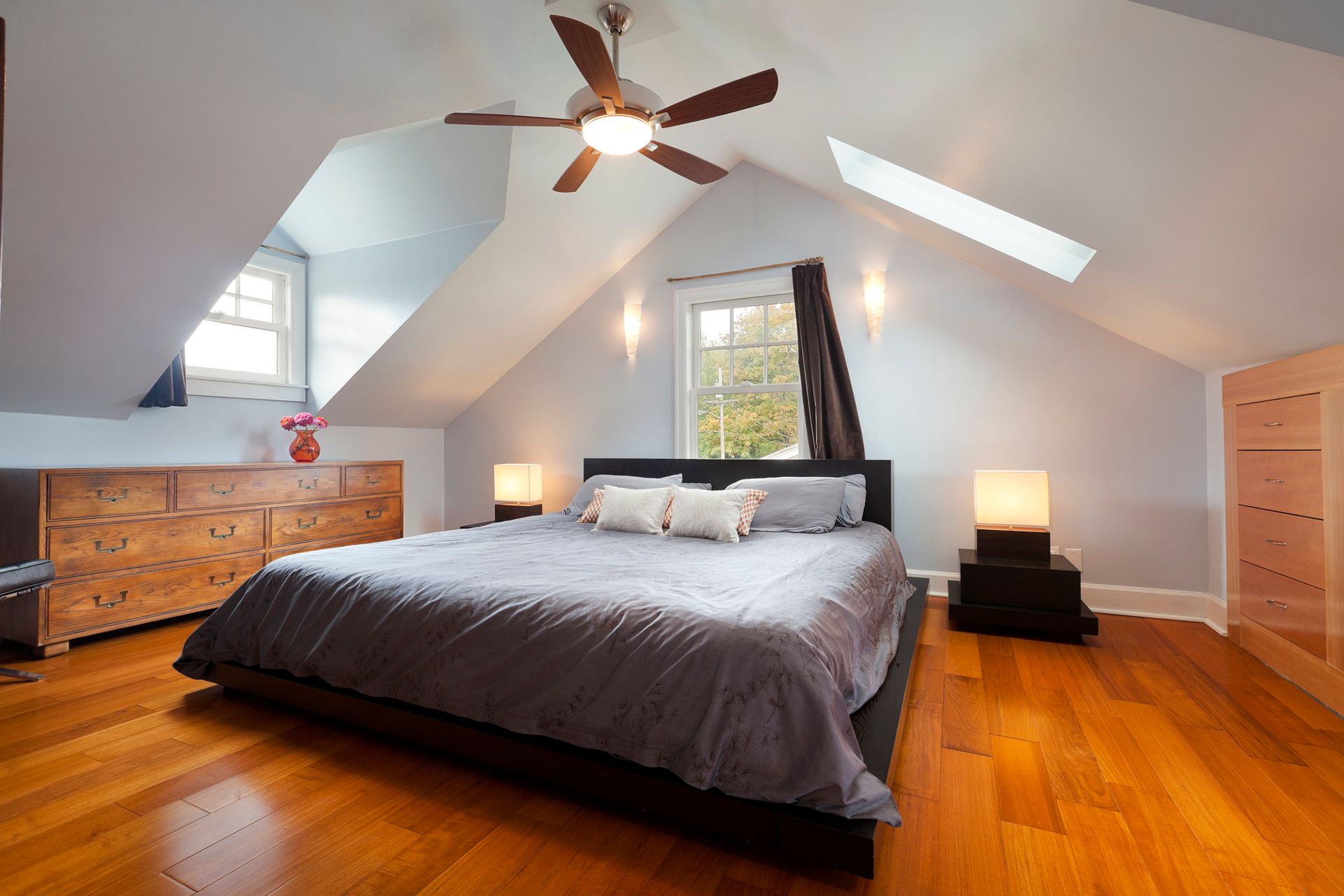 A bedroom with a large bed and a ceiling fan