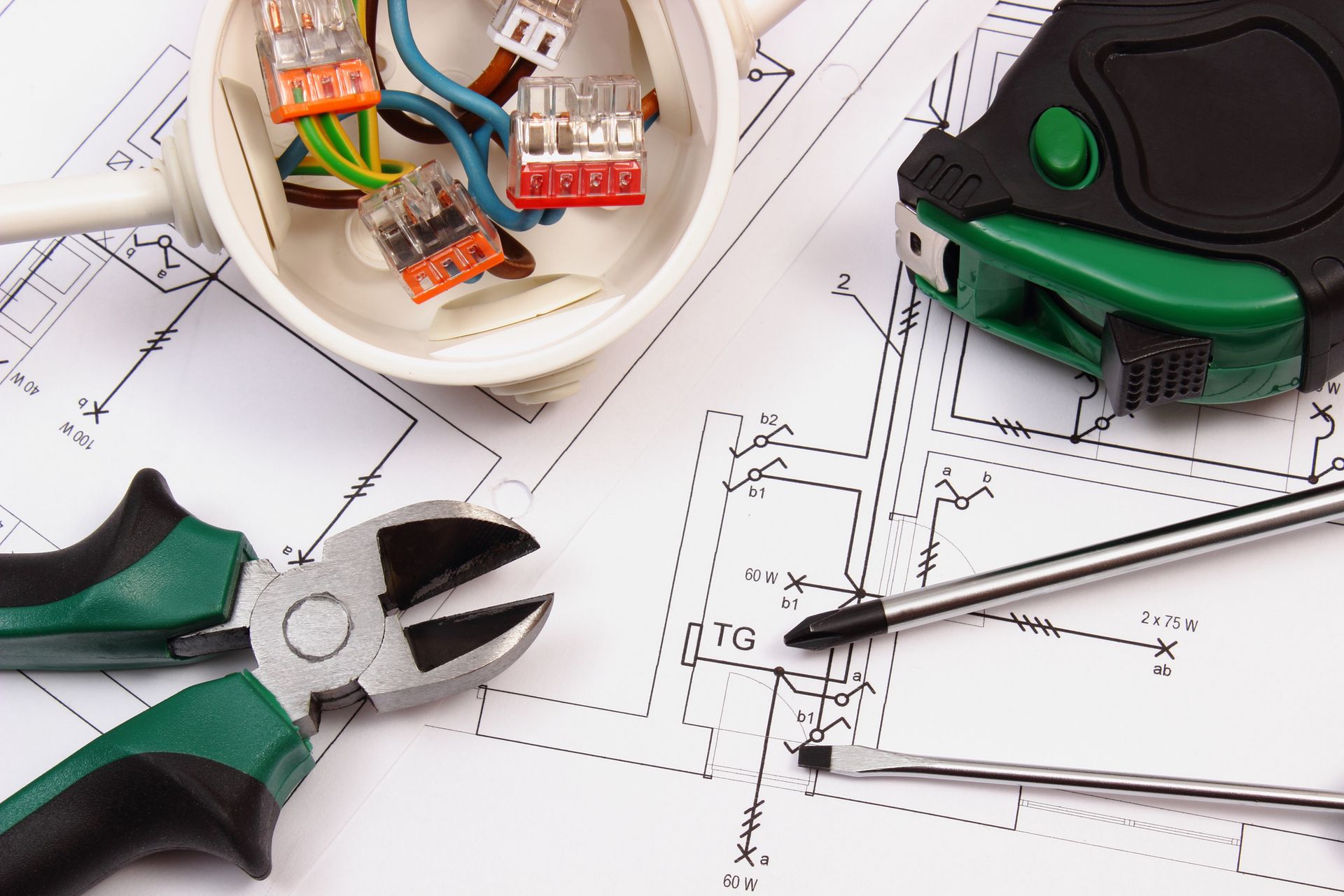 A pair of pliers a tape measure and a screwdriver on top of a drawing