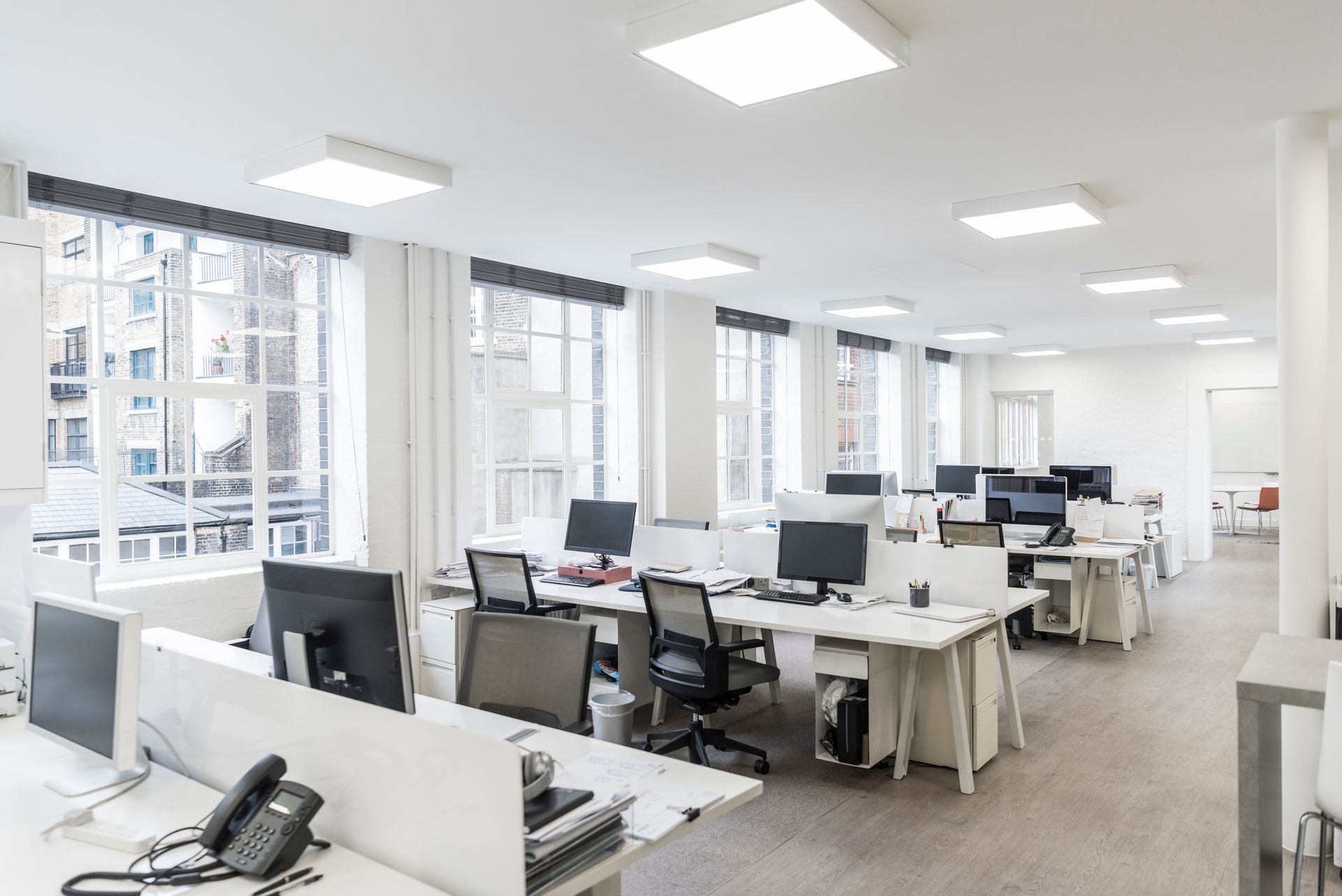 A large empty office with lots of desks and computers.