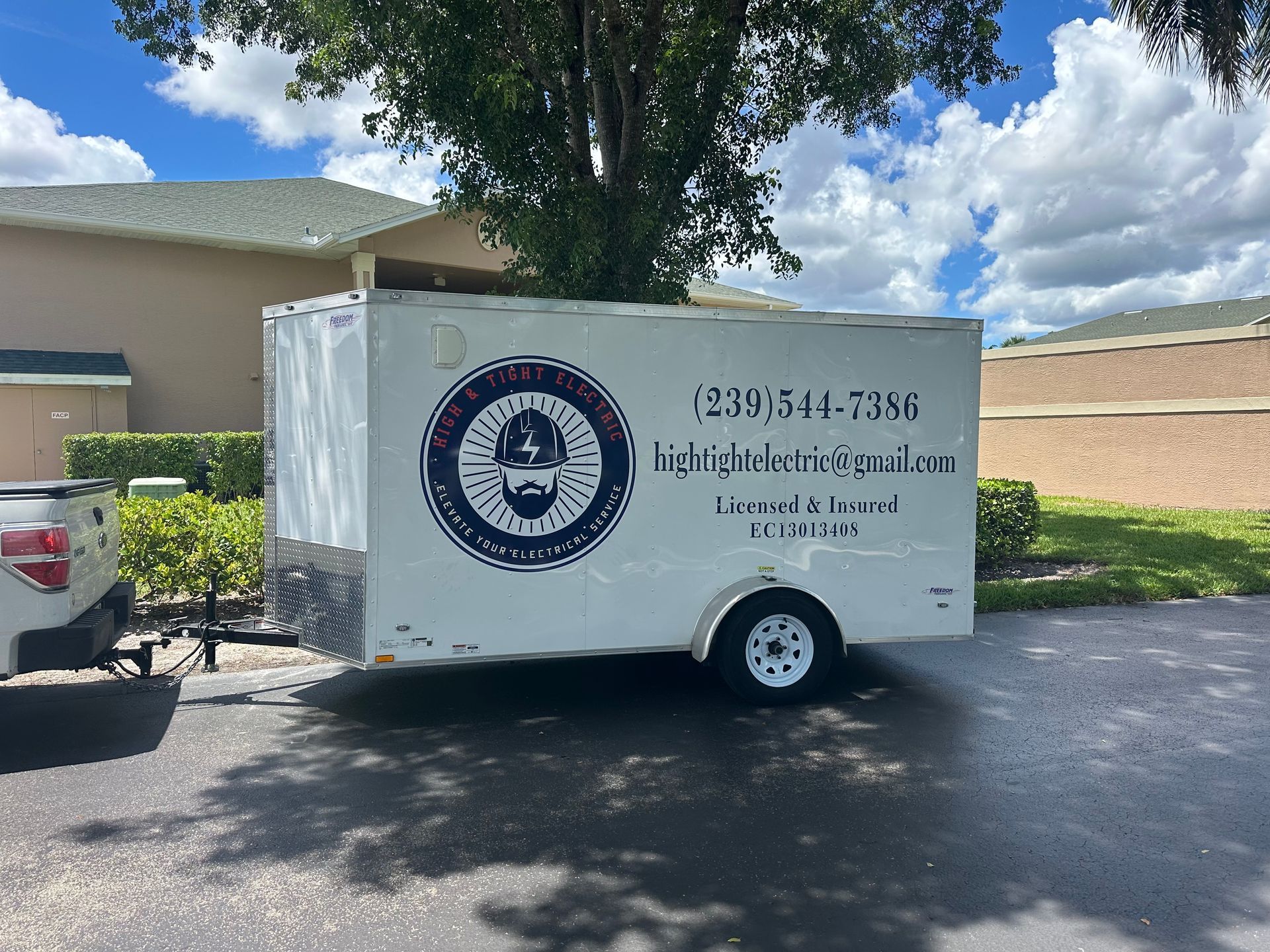 A white trailer is parked in front of a house