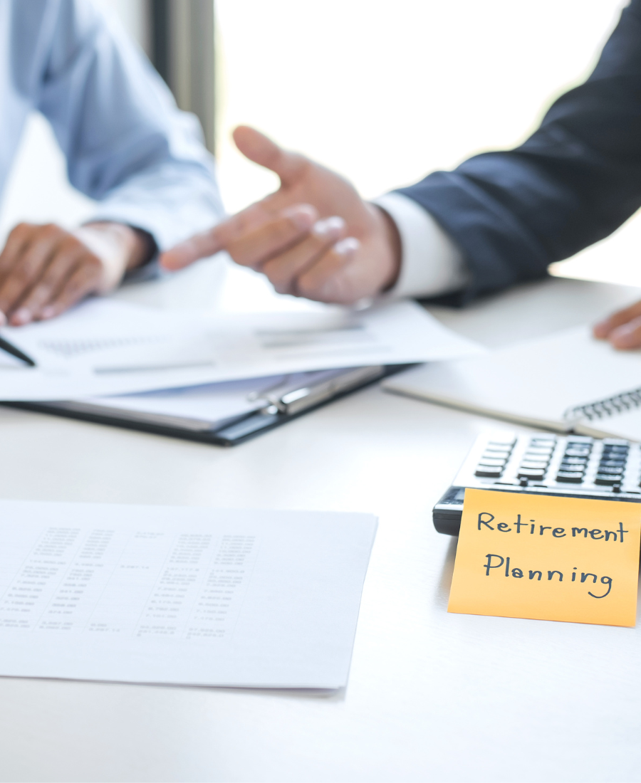 A man and a woman are sitting at a table with papers and a calculator.