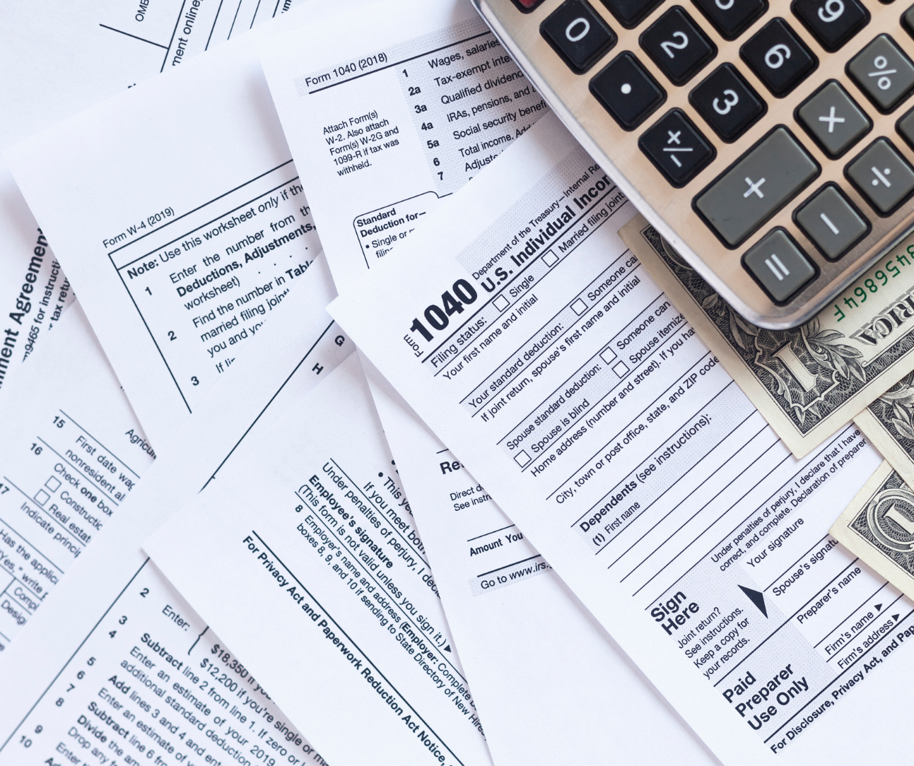 1040 tax forms and a calculator on top of them