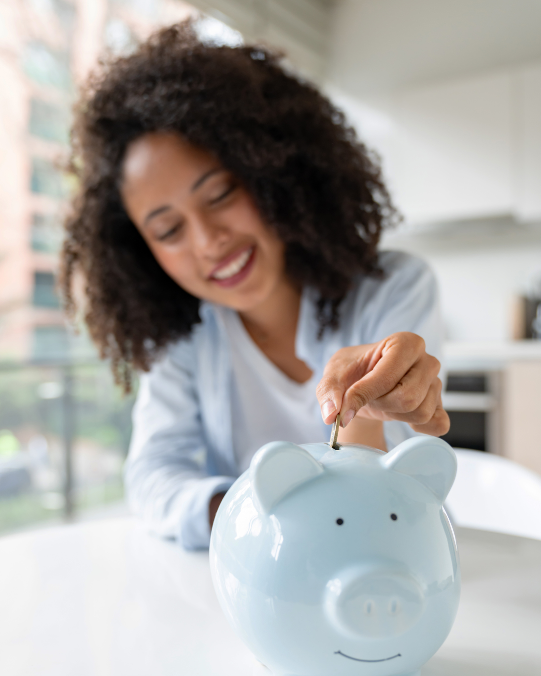 Lady adding money to a piggy bank