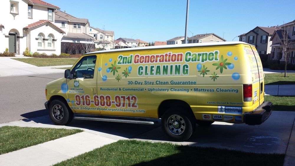 A 2nd generation carpet cleaning van is parked in front of a house