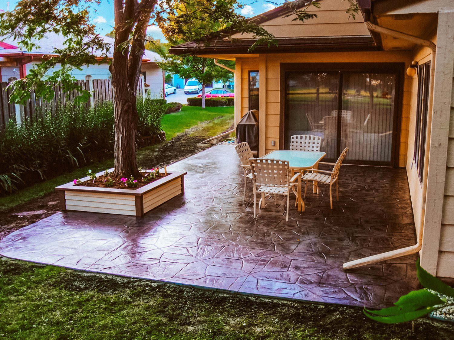 A patio with a table and chairs in front of a house