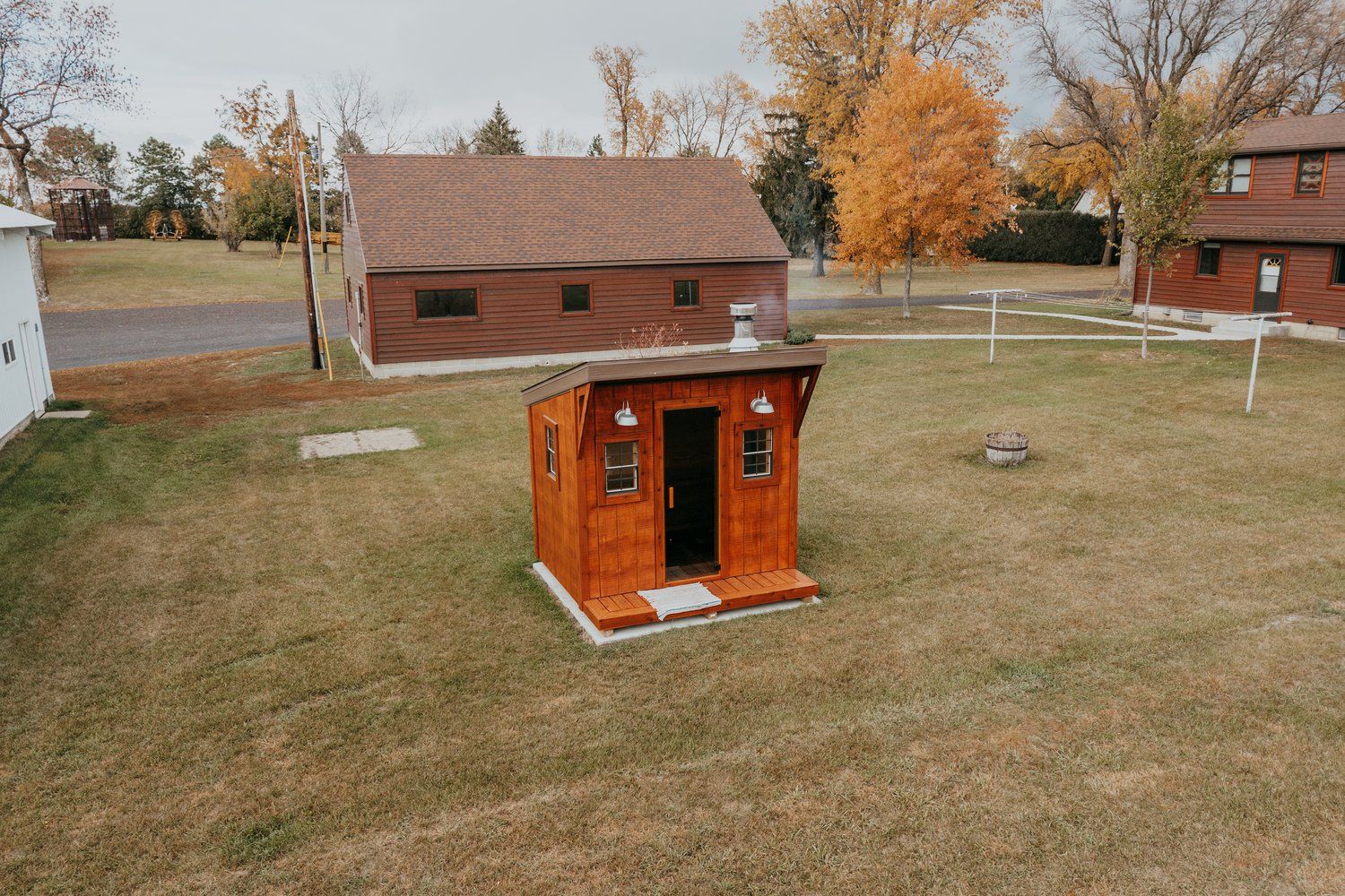 A small wooden house is sitting in the middle of a lush green field.