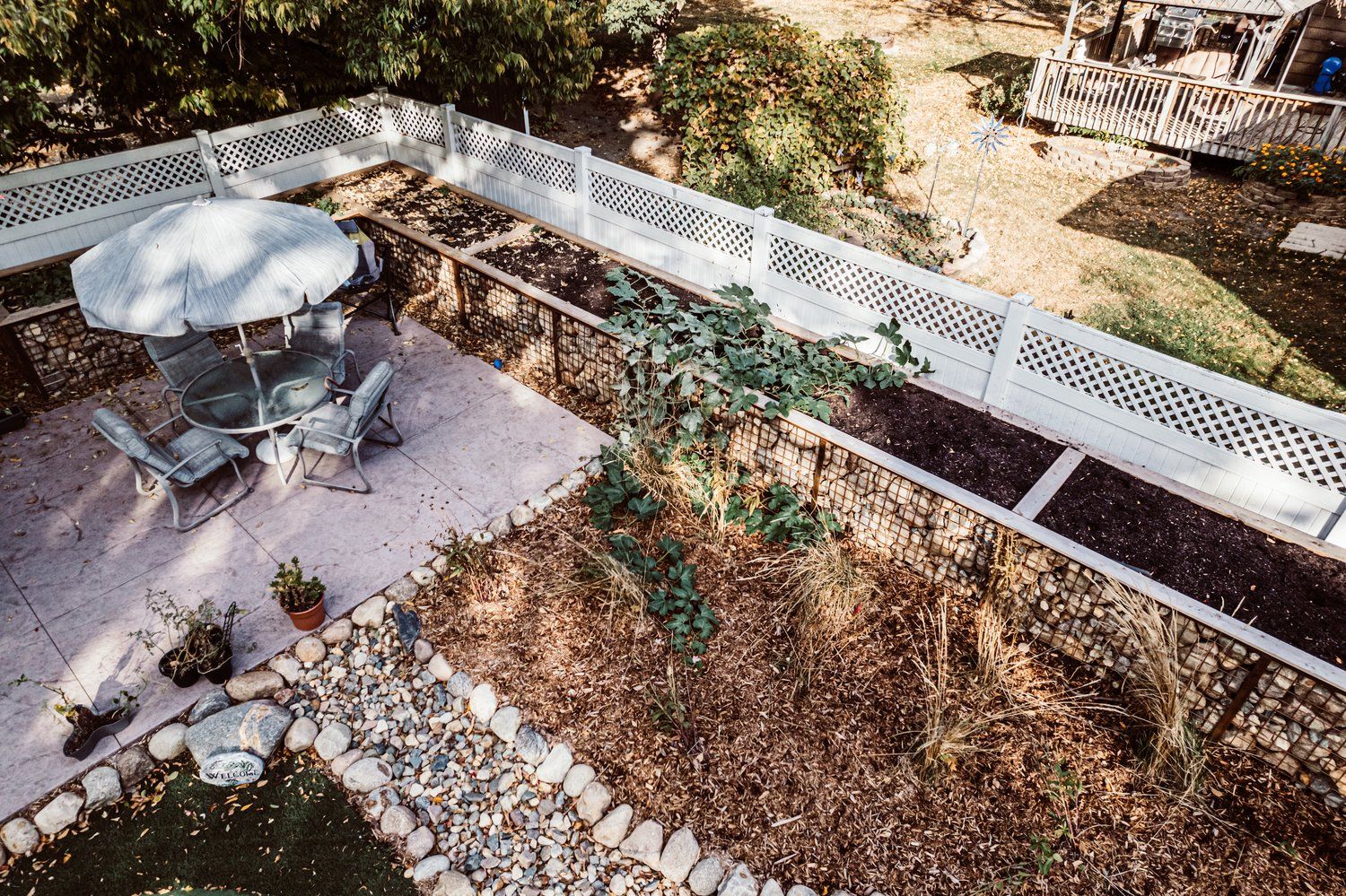 An aerial view of a backyard with a table and chairs and a fence.