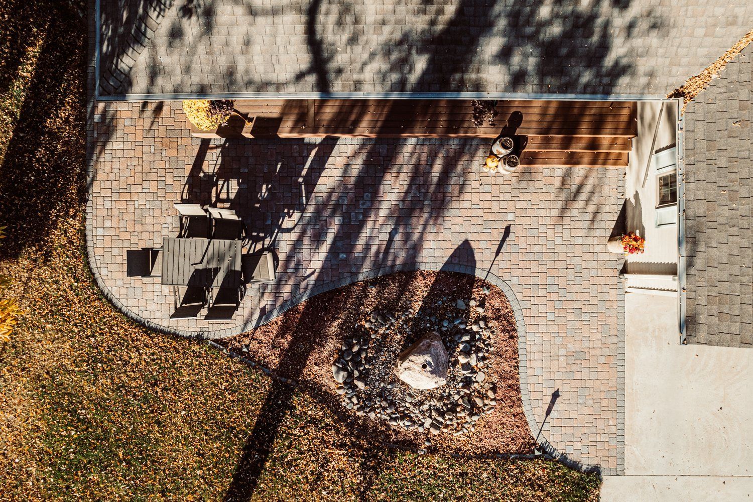 An aerial view of a patio with a fire pit and a grill.