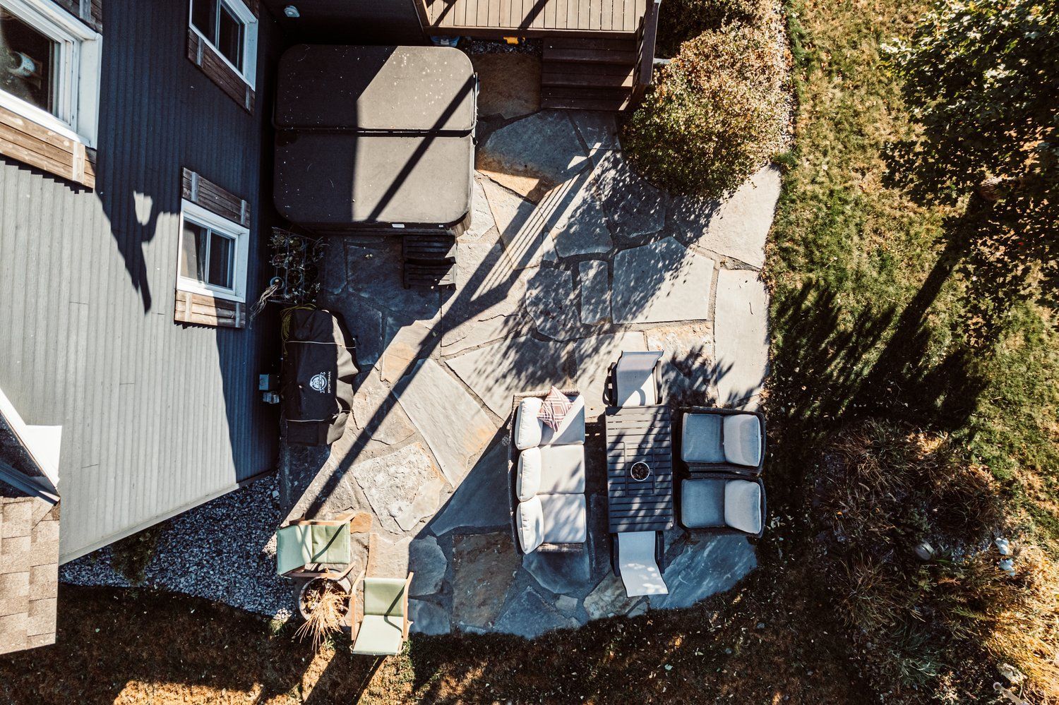 An aerial view of a patio with a table and chairs in front of a house.