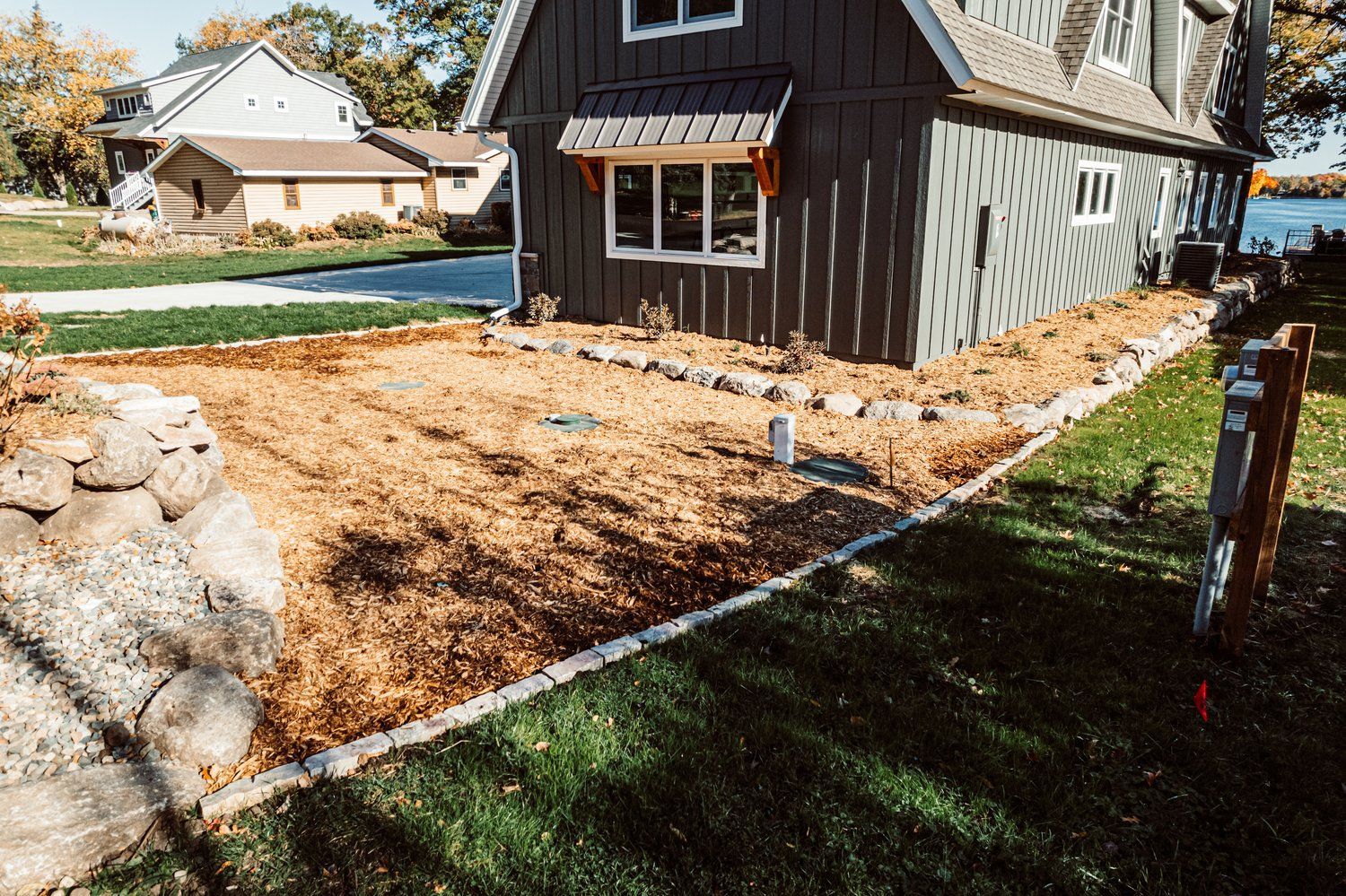 A house with a lot of windows is sitting next to a body of water.
