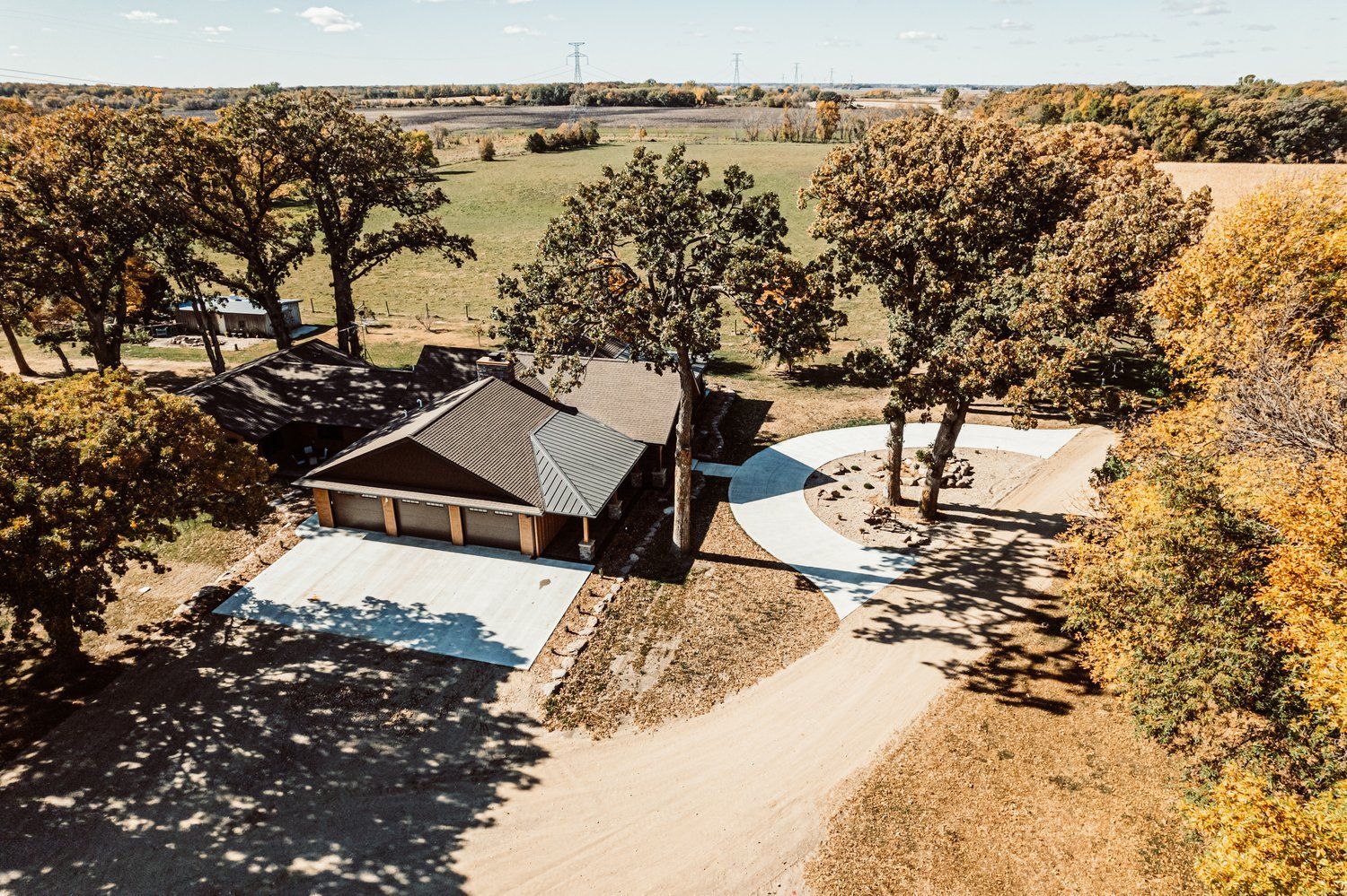 An aerial view of a house surrounded by trees and a driveway.