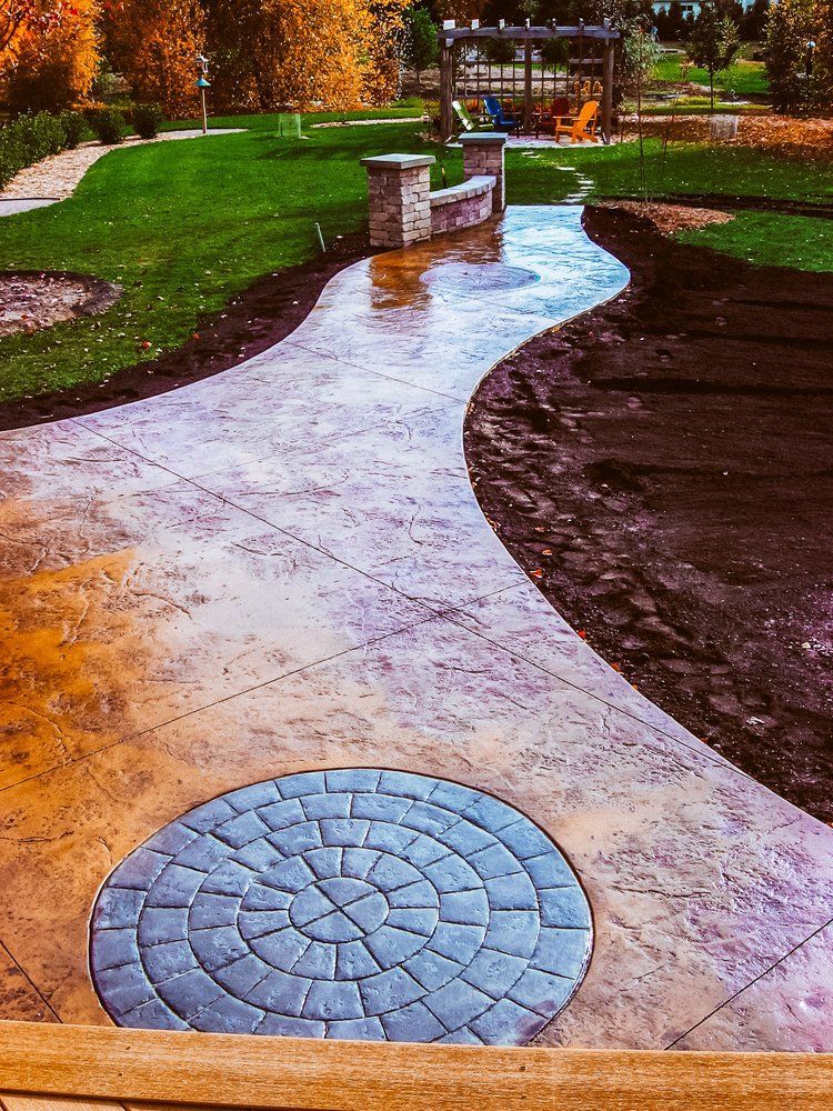 A concrete walkway with a circular design in the middle