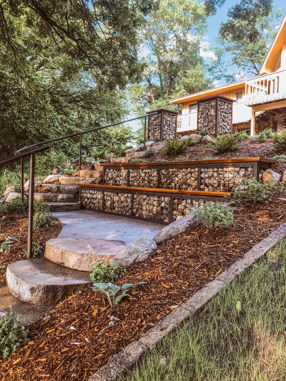 A stone staircase leading up to a house in a backyard.