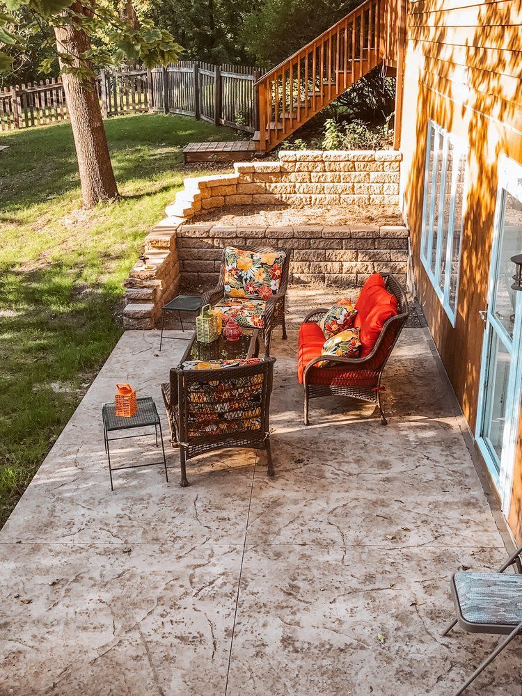 A patio with a table and chairs in front of a house.