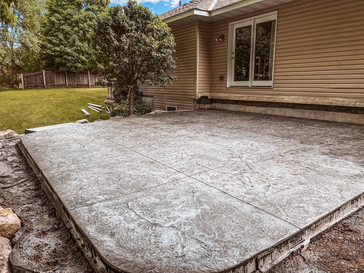 A concrete patio is being built in front of a house.