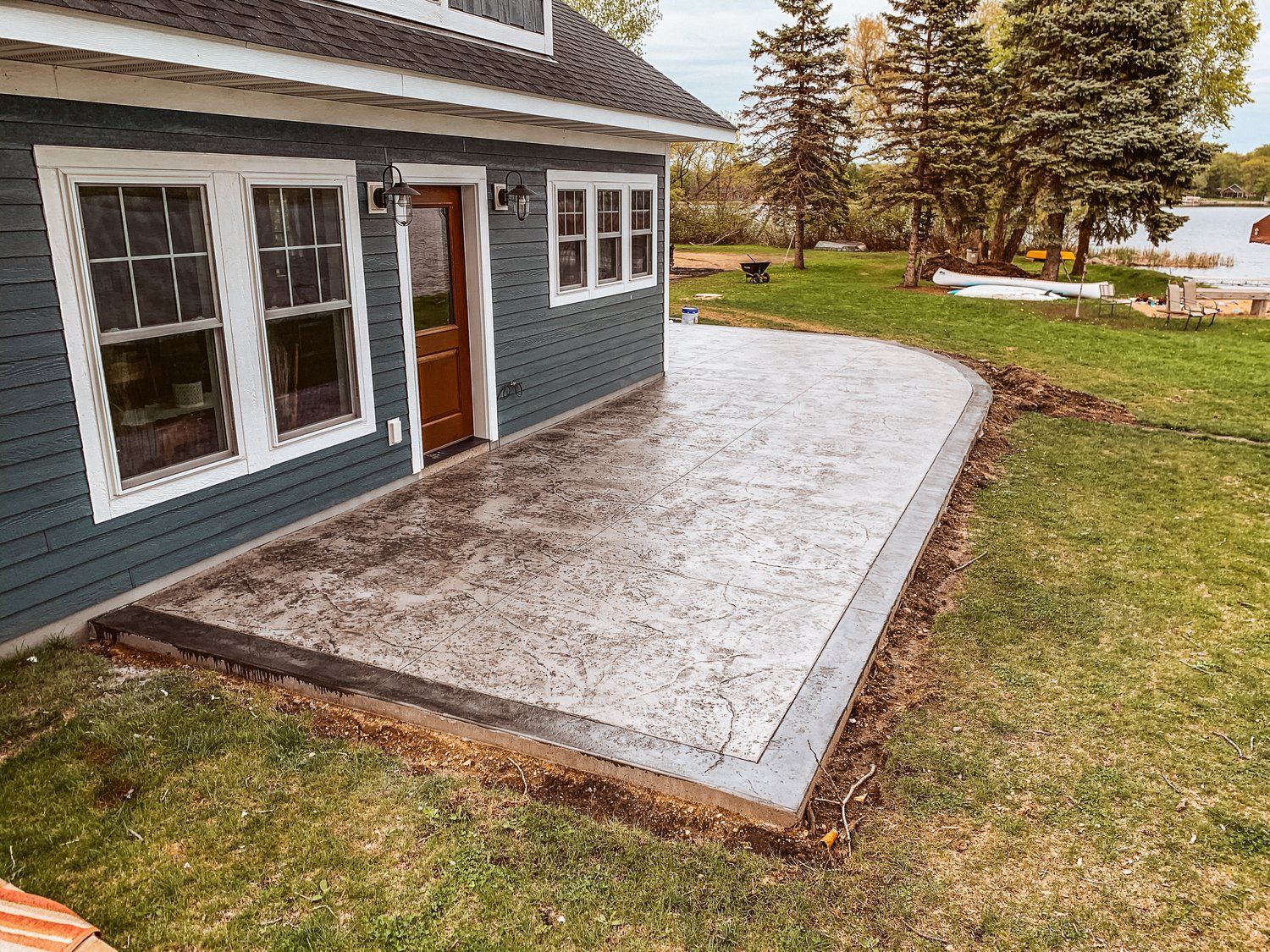 A blue house with a concrete patio in front of it.