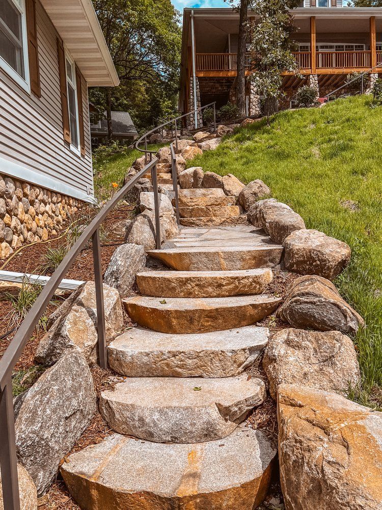 A set of stairs made of rocks leading up to a house.