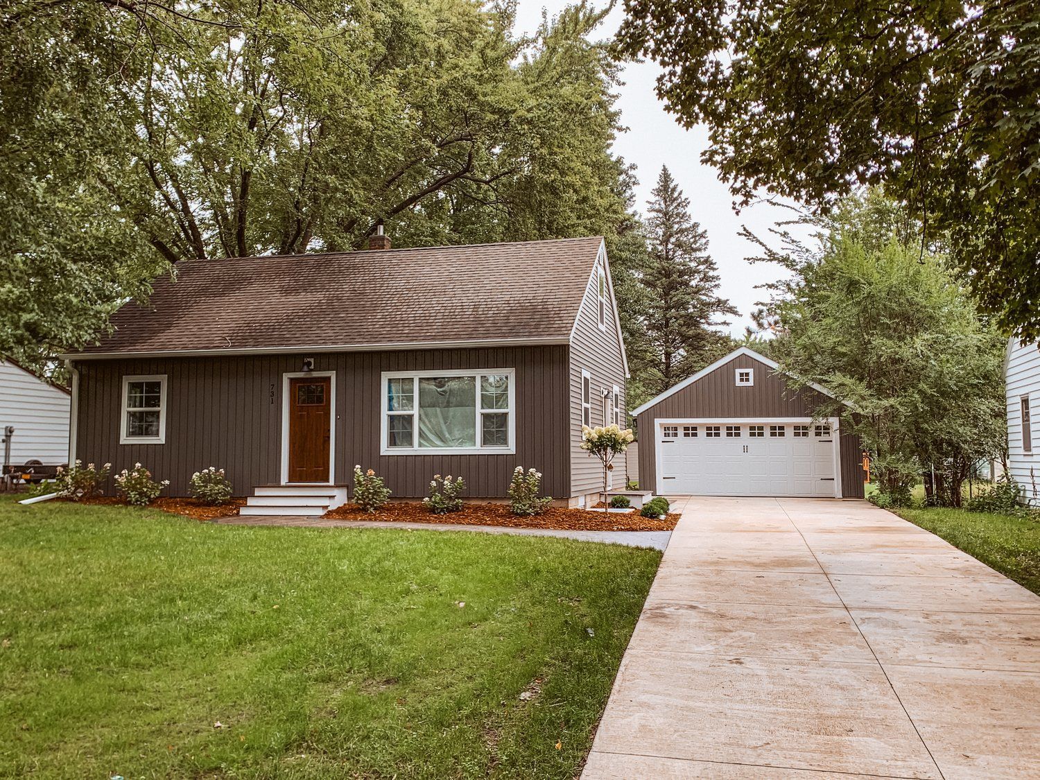 A house with a garage and a driveway in front of it.