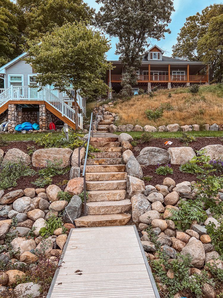 A dock with stairs leading up to a house on a hill.