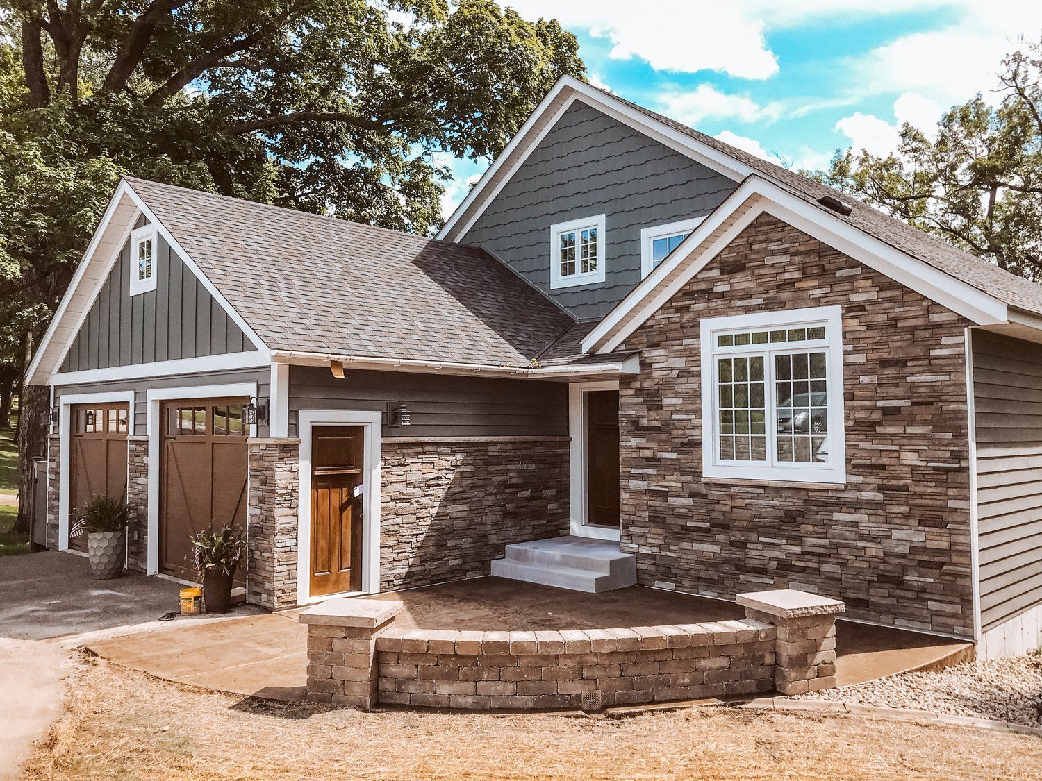 A large house with a stone facade and a garage.