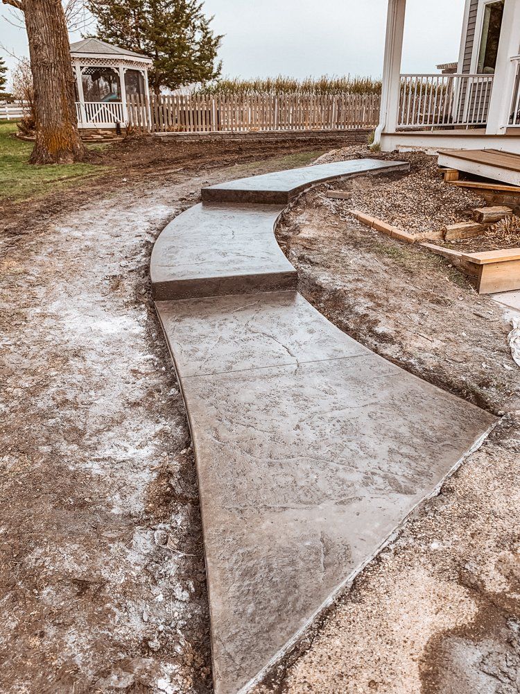 A concrete walkway is being built in front of a house.