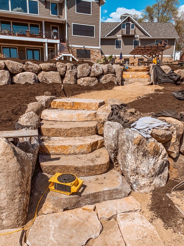 A house is being built next to a rock wall and stairs.