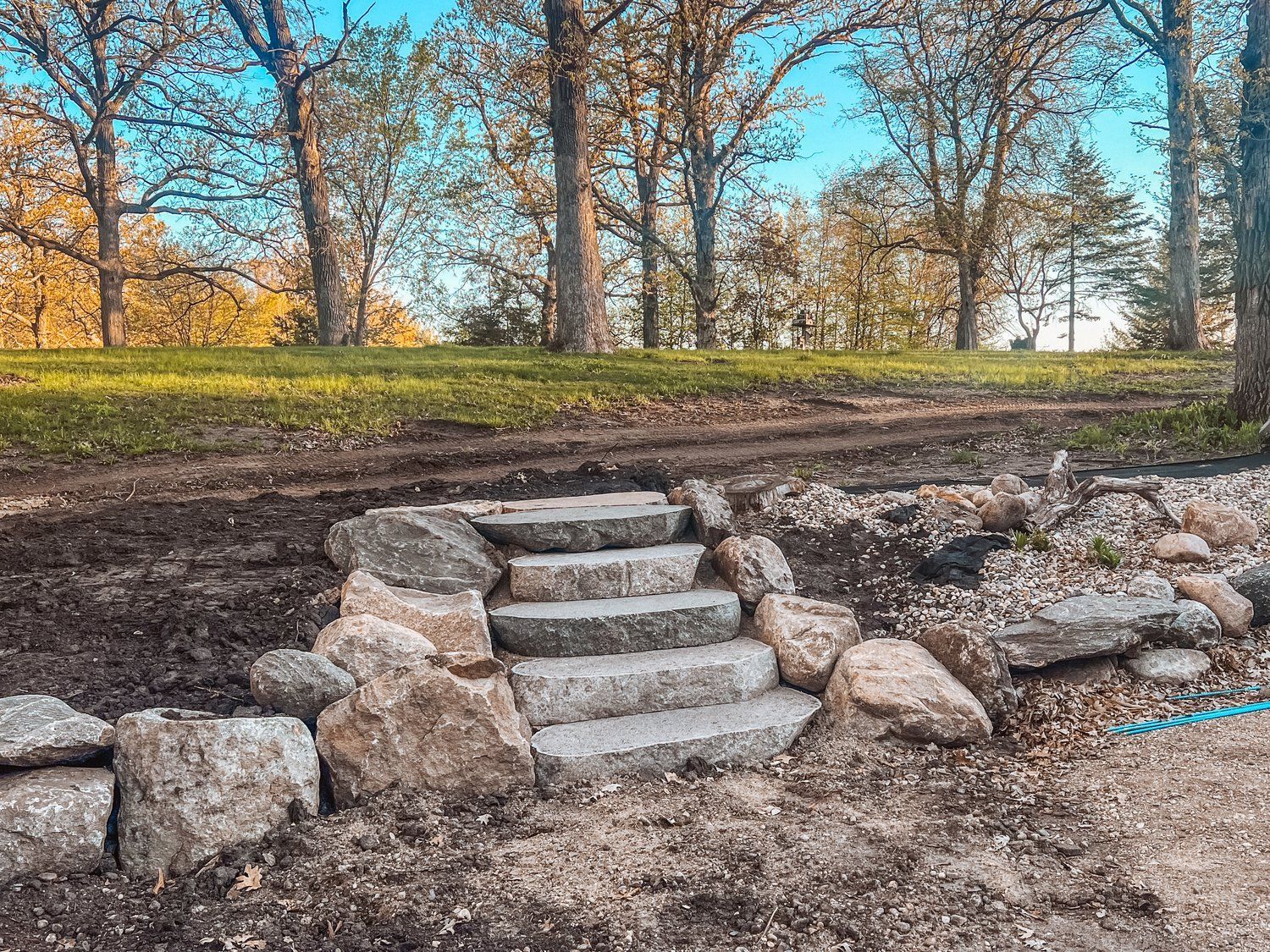 A set of stone stairs surrounded by rocks in a park.