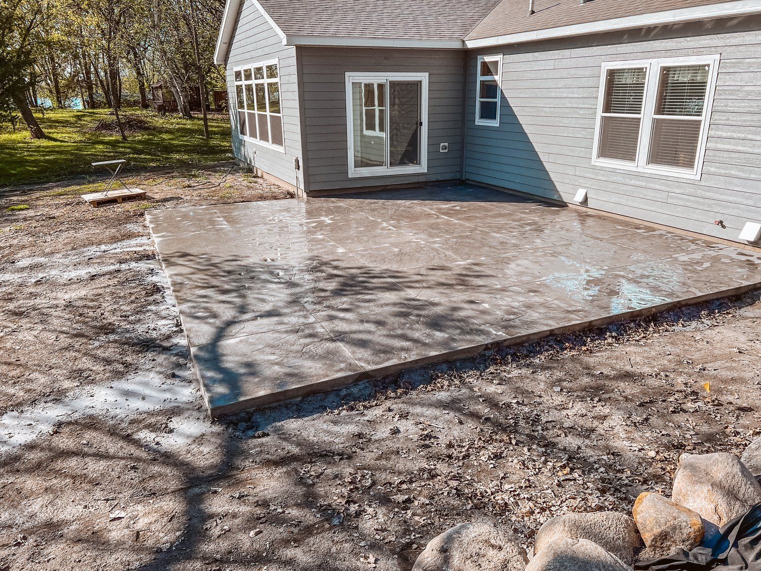 A concrete patio is being built in front of a house.
