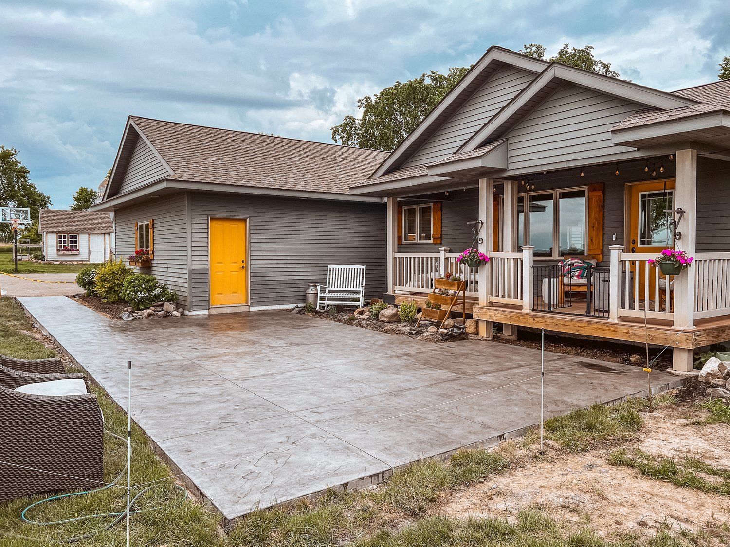 A house with a porch and a driveway in front of it.