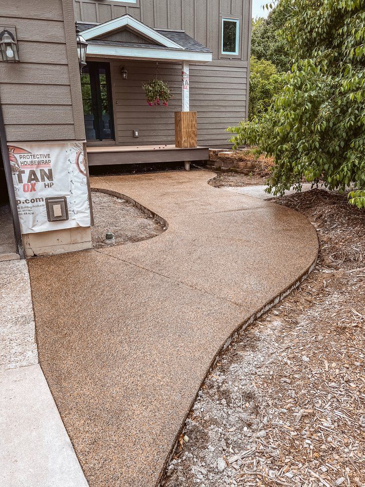 A concrete walkway leading to the front of a house.