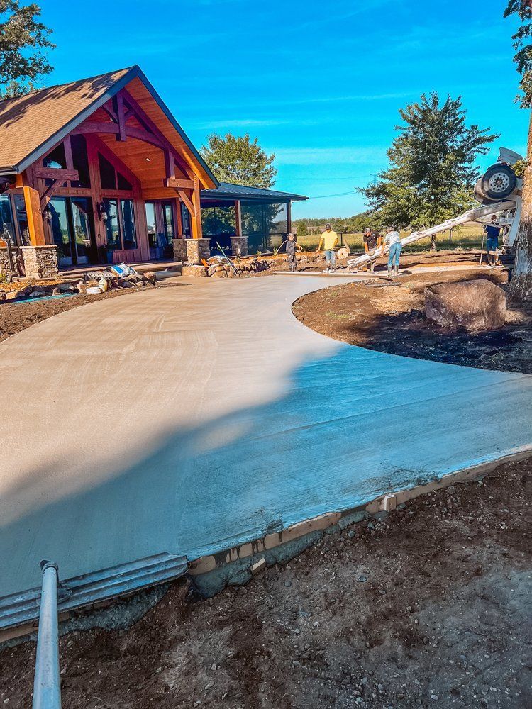 A concrete driveway is being poured in front of a house.