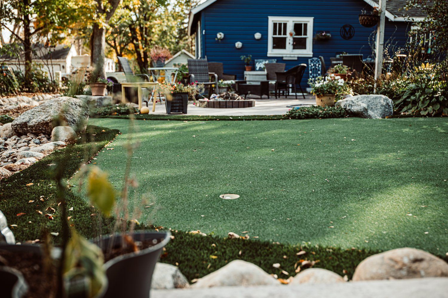A blue house with a lush green lawn in front of it.