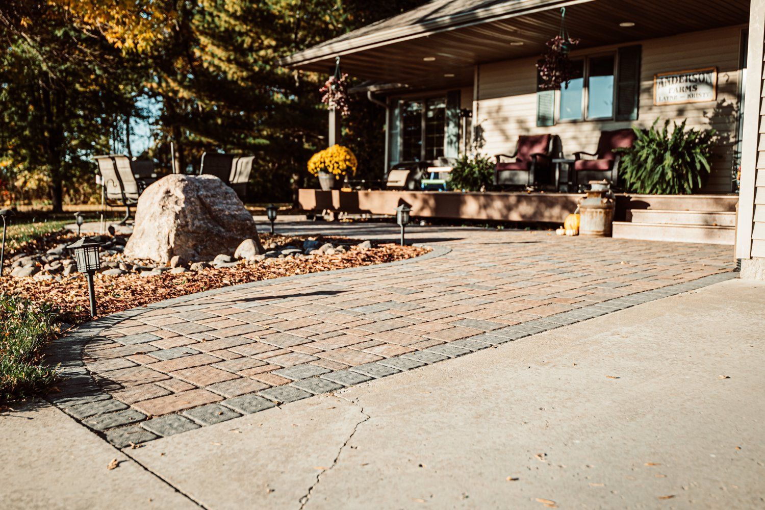 A house with a patio and a large rock in front of it.
