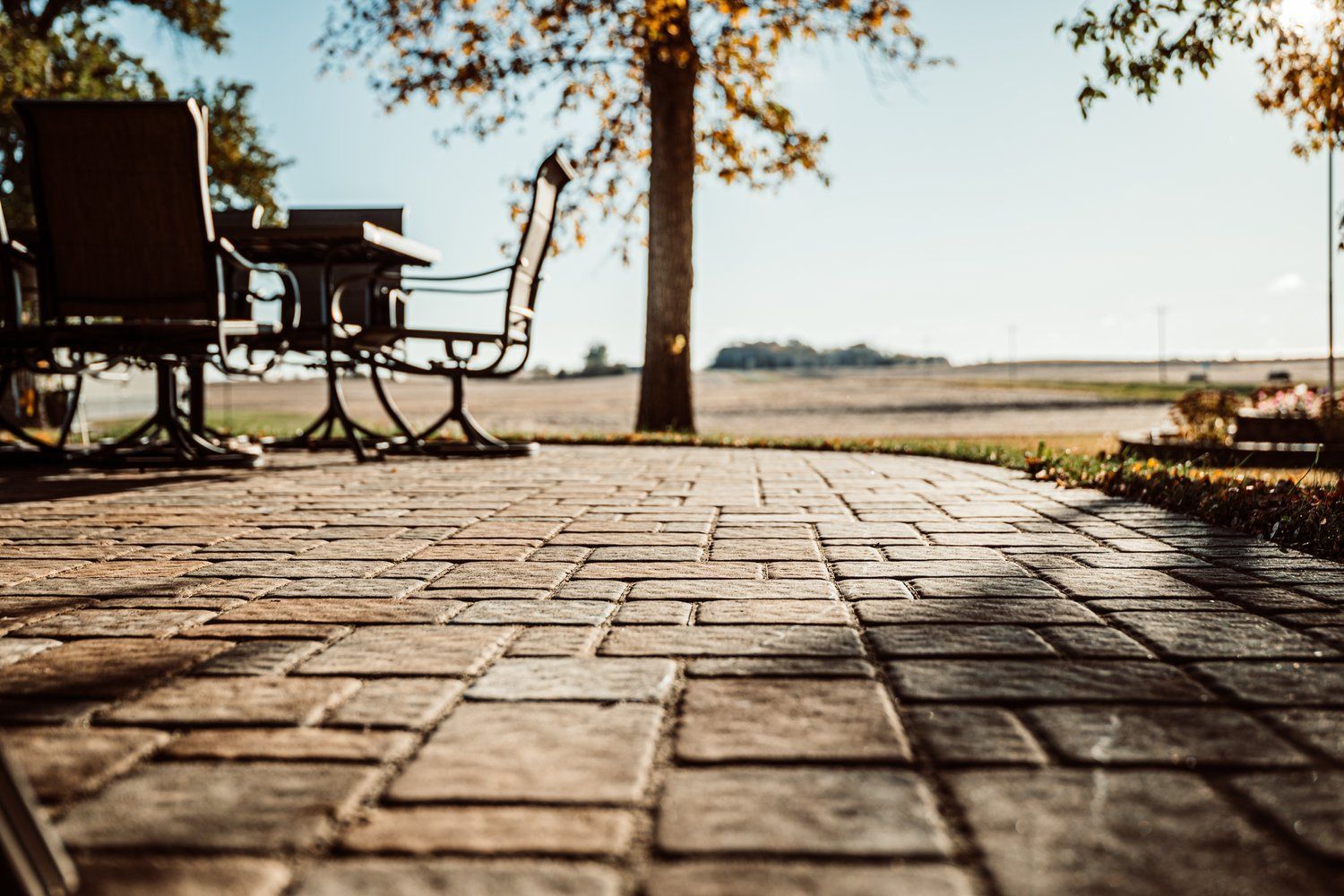 A patio with a table and chairs under a tree.