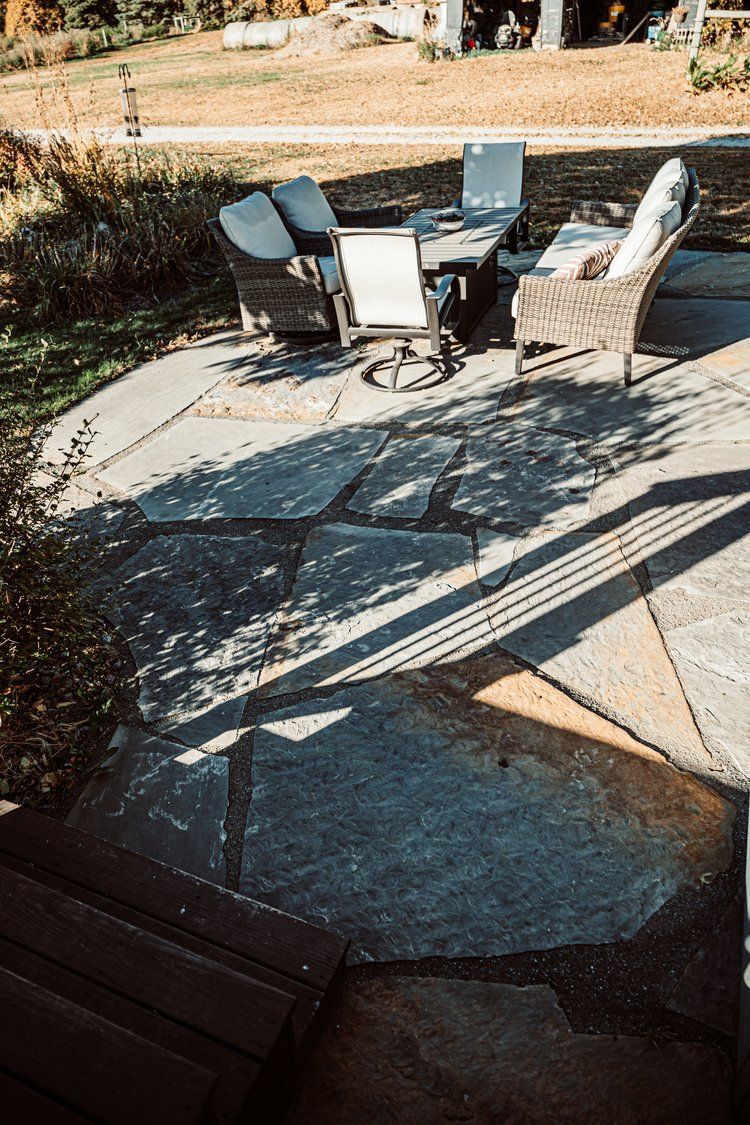 A patio with a table and chairs on it.