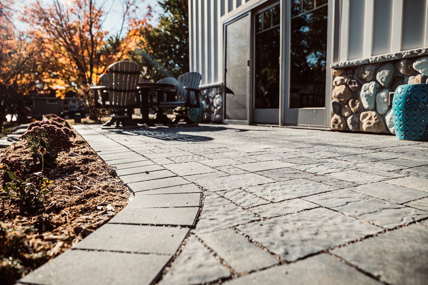 A patio with a table and chairs in front of a house.