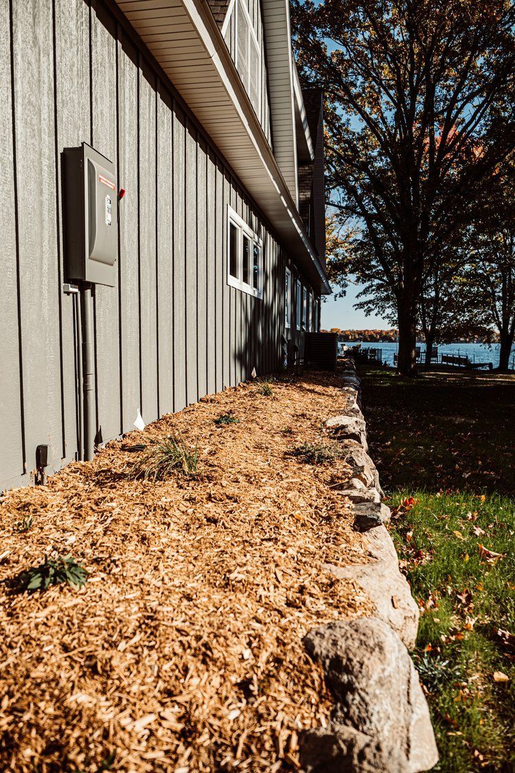 A house with a lot of mulch on the side of it.