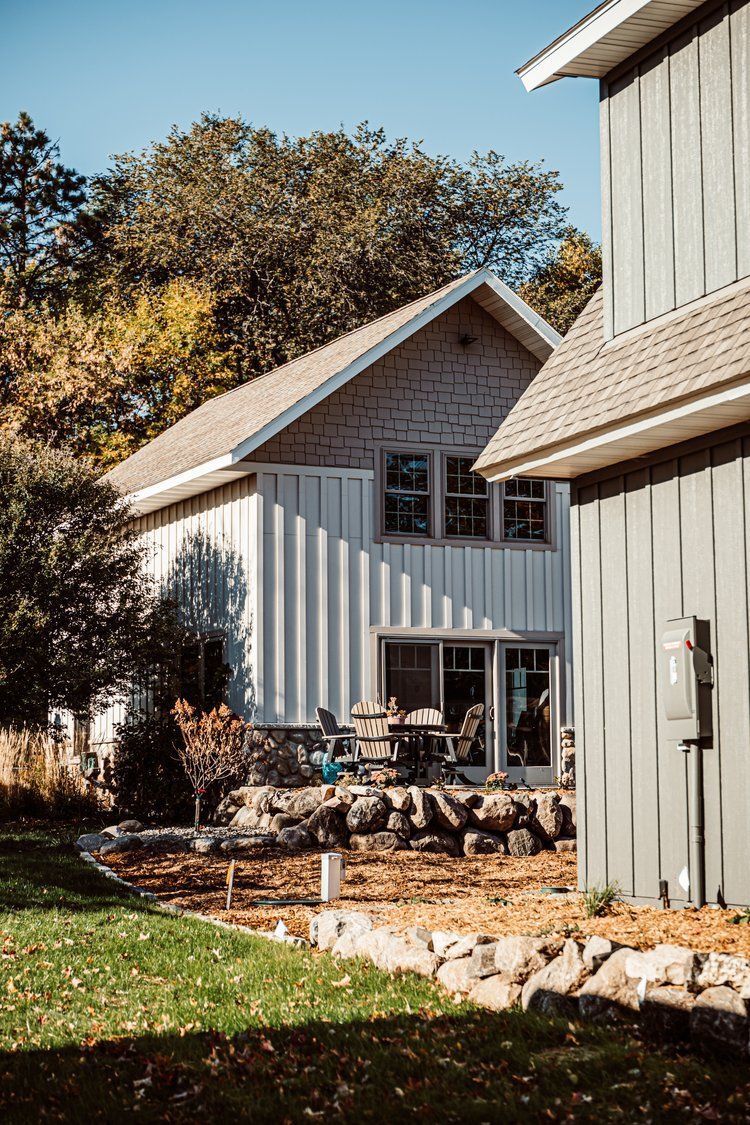 A couple of houses sitting next to each other on top of a lush green field.