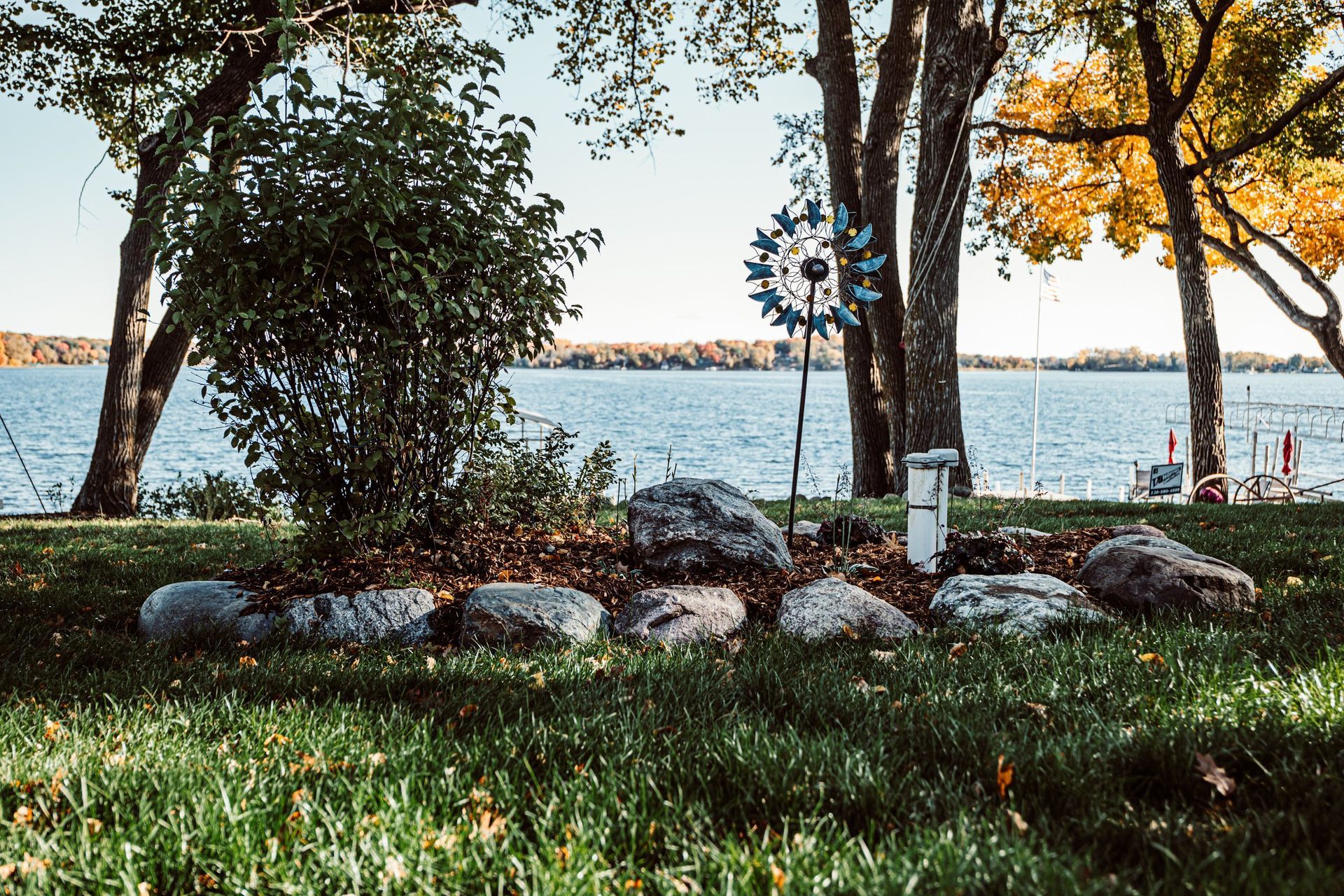 There is a lake in the background and a windmill in the foreground.