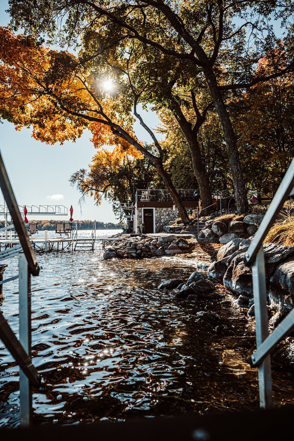 A staircase leading to a dock on a lake surrounded by trees.