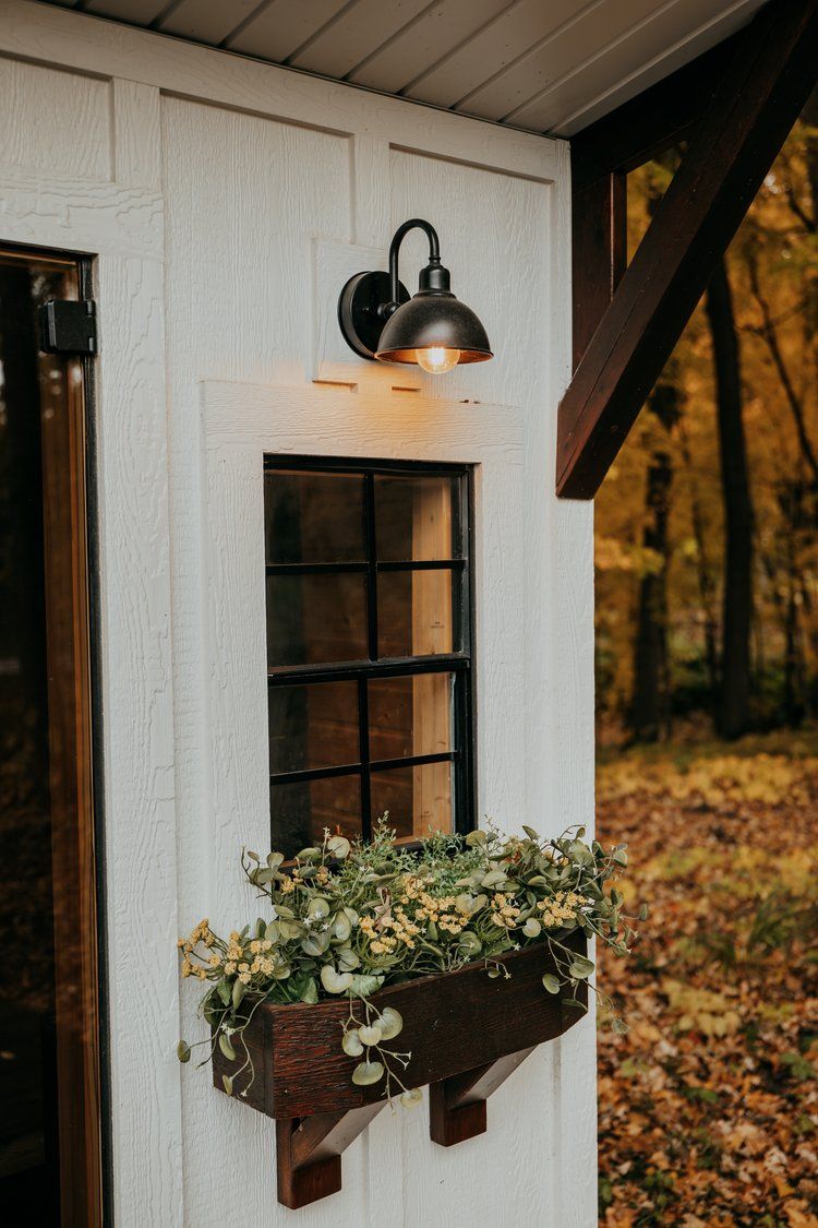A white building with a window and a light on the side.