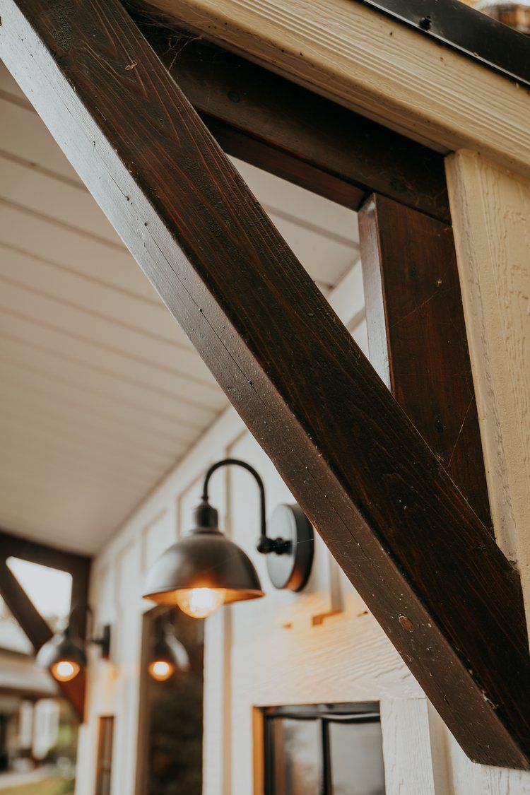 A close up of a wooden beam with a light hanging from it.