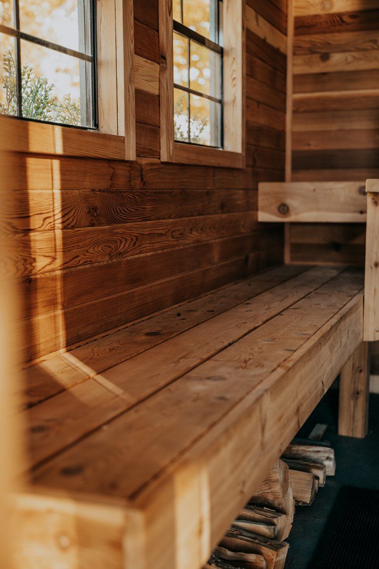 A wooden bench in a wooden room with a window.