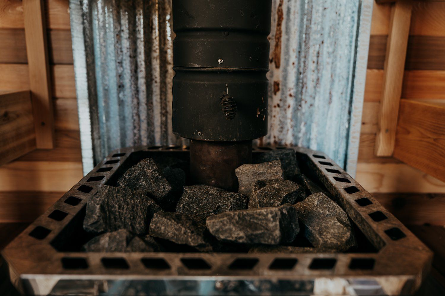 A close up of a sauna stove with rocks in it.