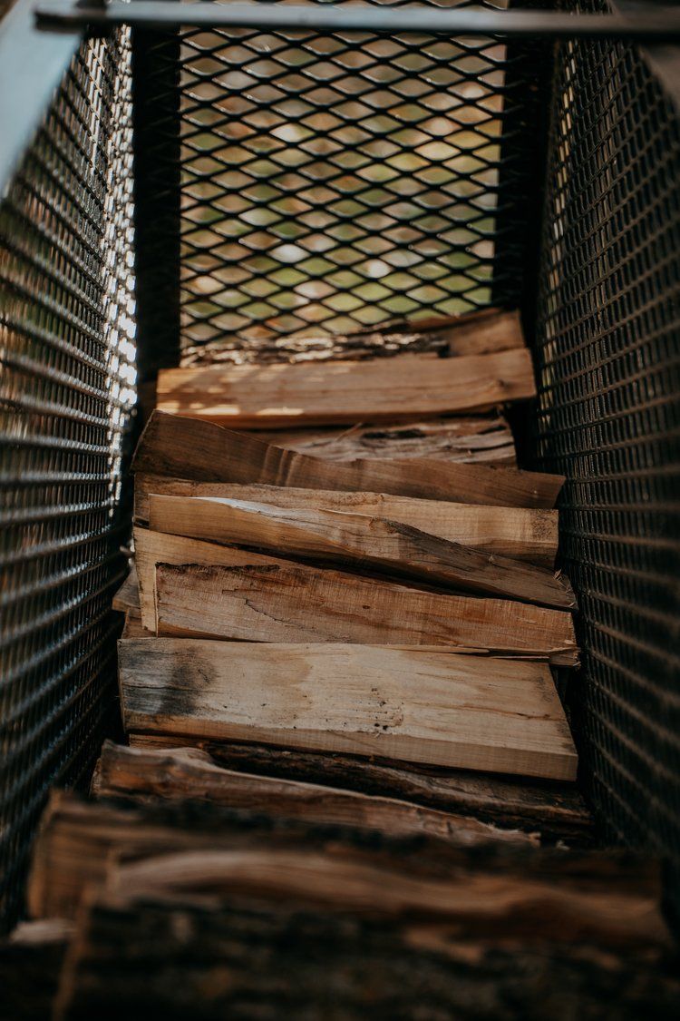 A pile of wood is sitting inside of a metal container.