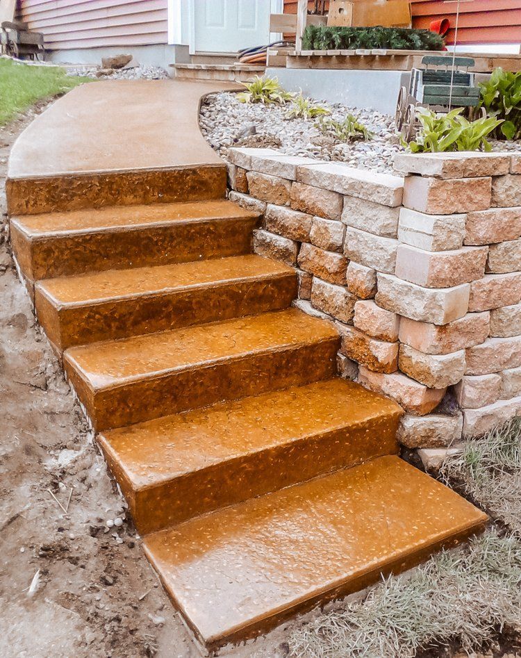 A set of stairs leading up to a house next to a brick wall.